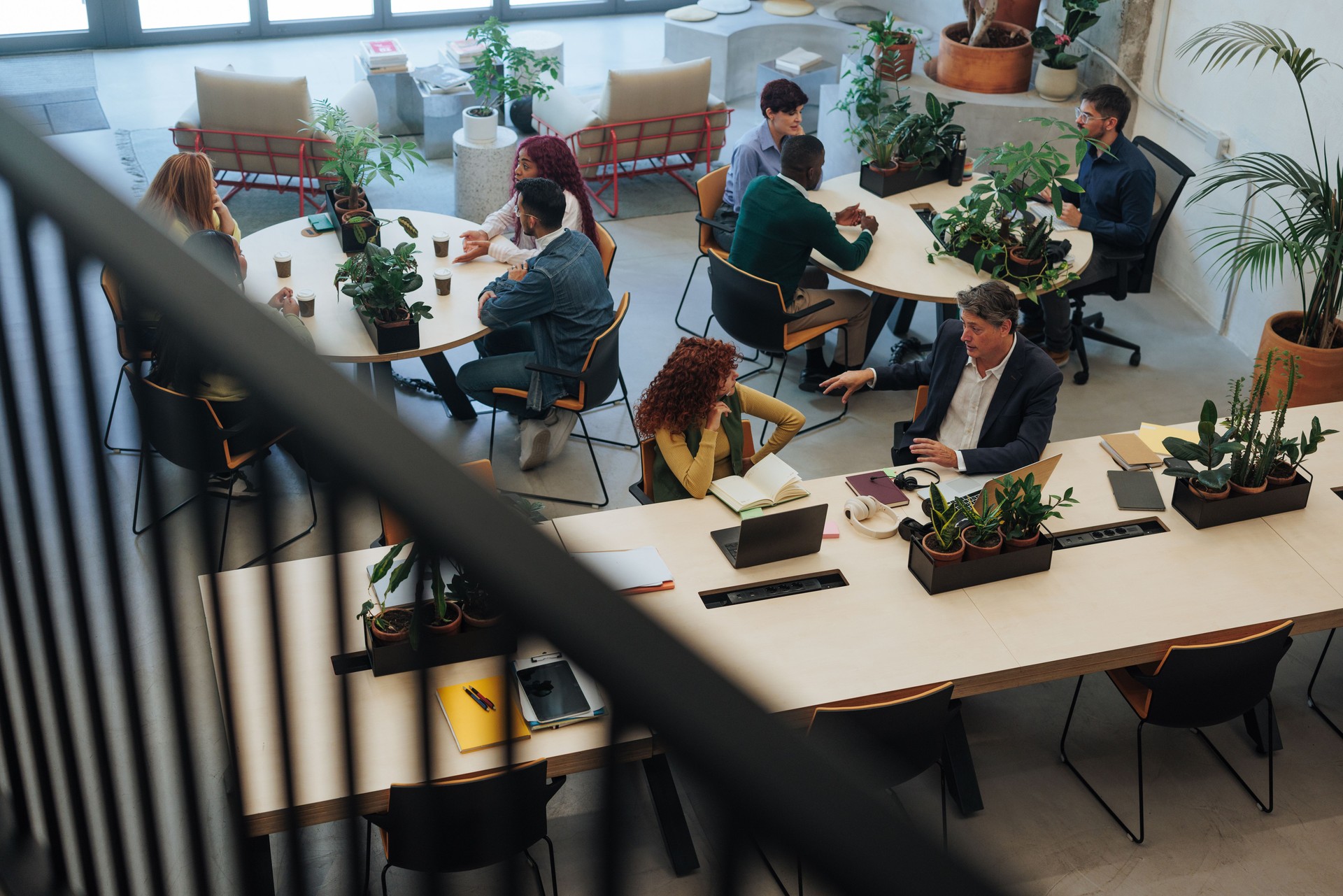Coworkers collaborating and discussing projects in modern green office space